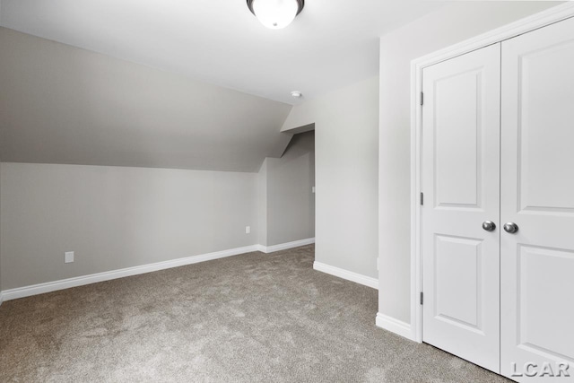 bonus room featuring vaulted ceiling and light colored carpet