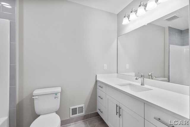 bathroom featuring toilet, a shower, tile patterned floors, and vanity