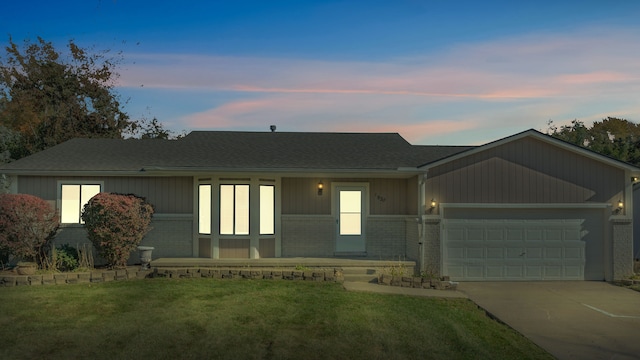 single story home featuring a lawn and a garage