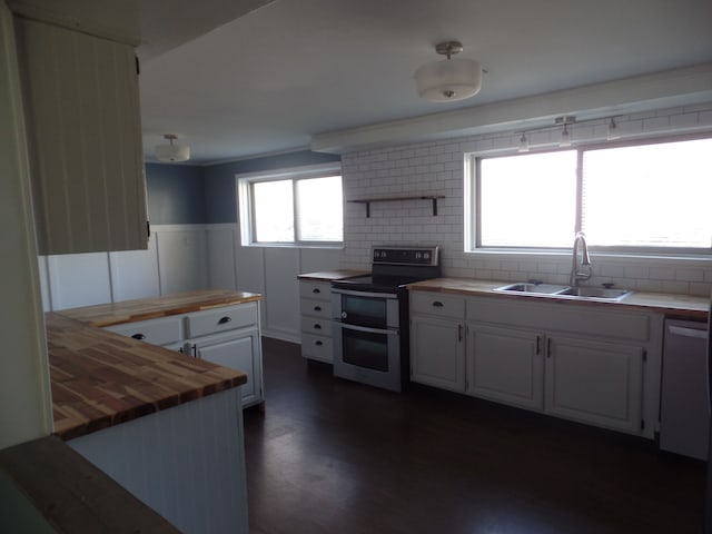 kitchen with butcher block counters, sink, stainless steel electric range oven, dark hardwood / wood-style flooring, and white cabinetry