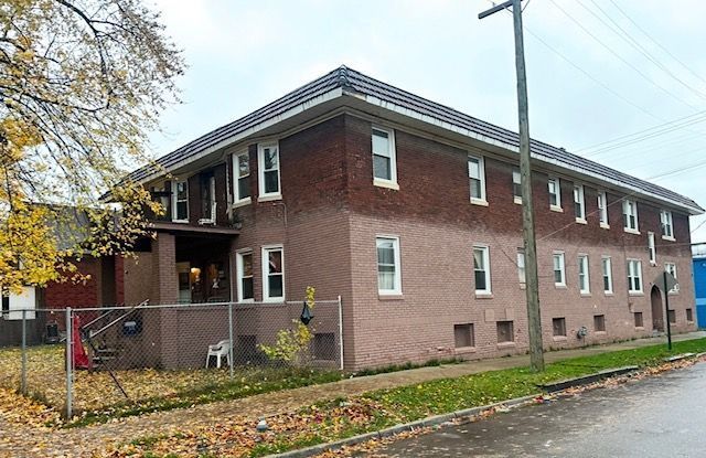 view of home's exterior with brick siding and fence