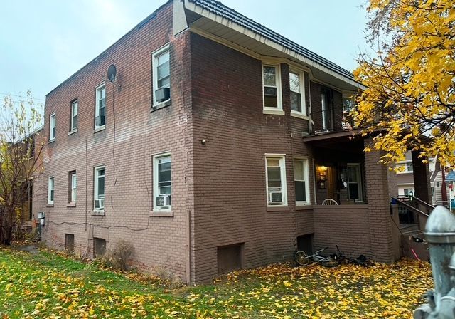 view of home's exterior with cooling unit, brick siding, and a yard