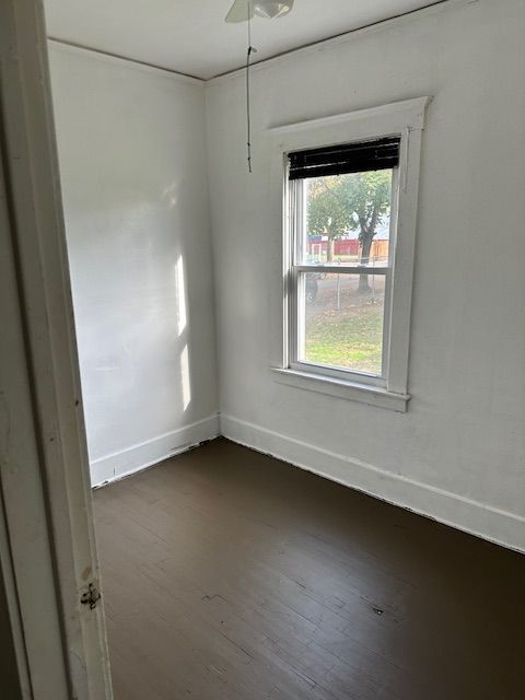 empty room featuring dark hardwood / wood-style flooring and ceiling fan