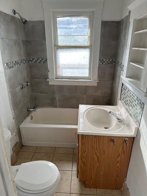 bathroom featuring shower / bath combination, toilet, vanity, and tile patterned flooring