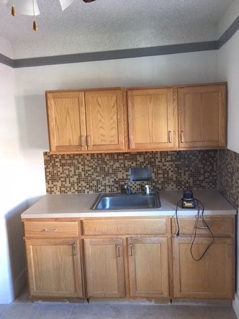 kitchen with light tile patterned floors, tasteful backsplash, and sink