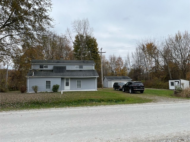 view of property with a storage unit and a front lawn