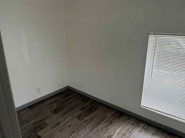 unfurnished room with dark wood-type flooring