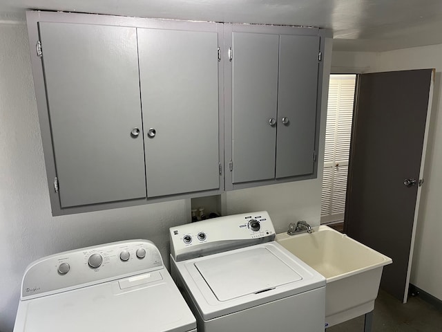 laundry area featuring washer and dryer, cabinets, and sink