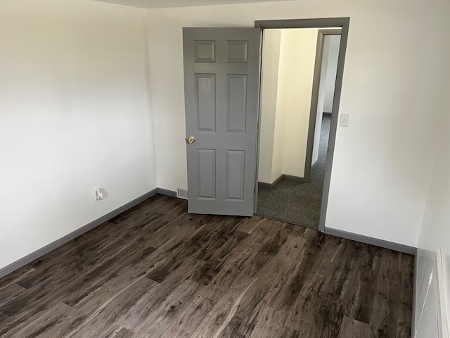 empty room with dark hardwood / wood-style flooring