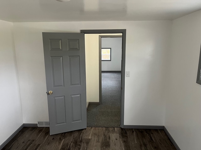 spare room featuring dark wood-type flooring