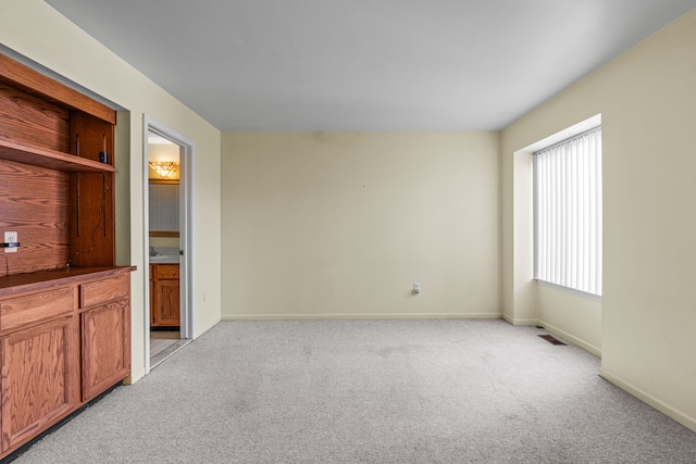 spare room featuring light colored carpet