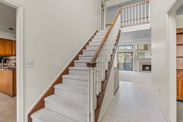 stairway with a fireplace, tile patterned flooring, and sink