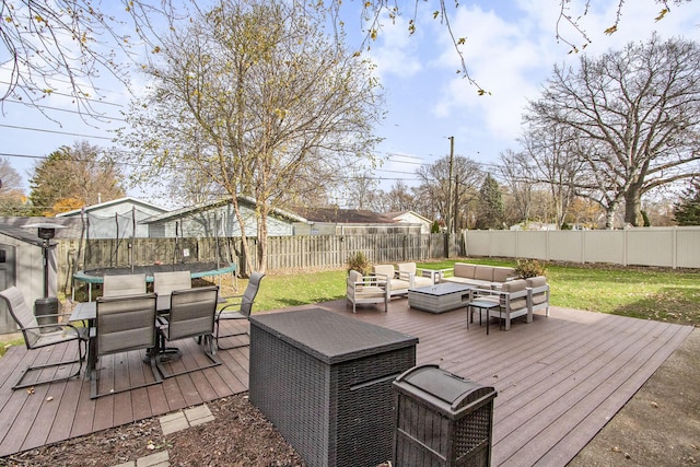 deck with outdoor lounge area, a trampoline, and a yard