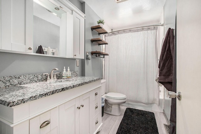 full bathroom with bathing tub / shower combination, hardwood / wood-style floors, vanity, and toilet