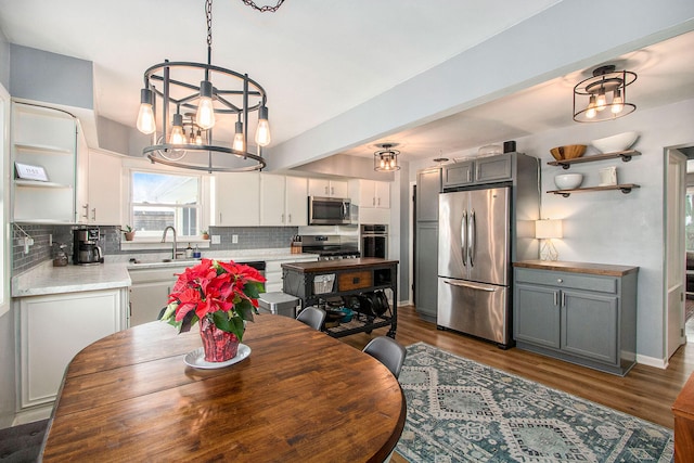 dining area with dark hardwood / wood-style floors, a notable chandelier, and sink