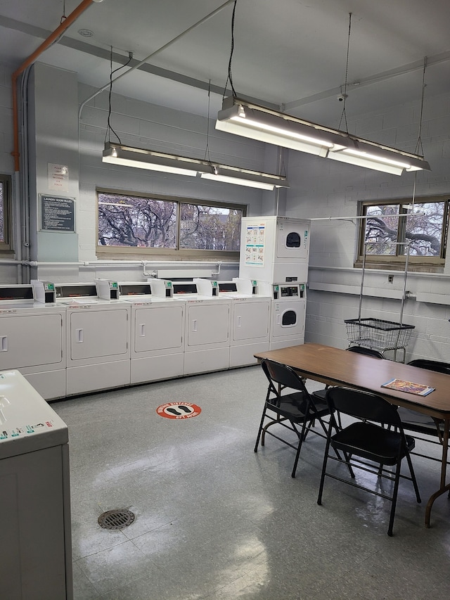 interior space with white cabinetry, a healthy amount of sunlight, washer and clothes dryer, and stacked washing maching and dryer