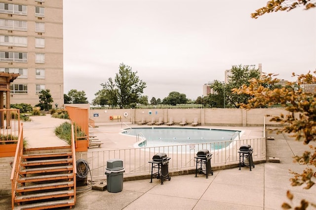 view of swimming pool featuring a patio and grilling area