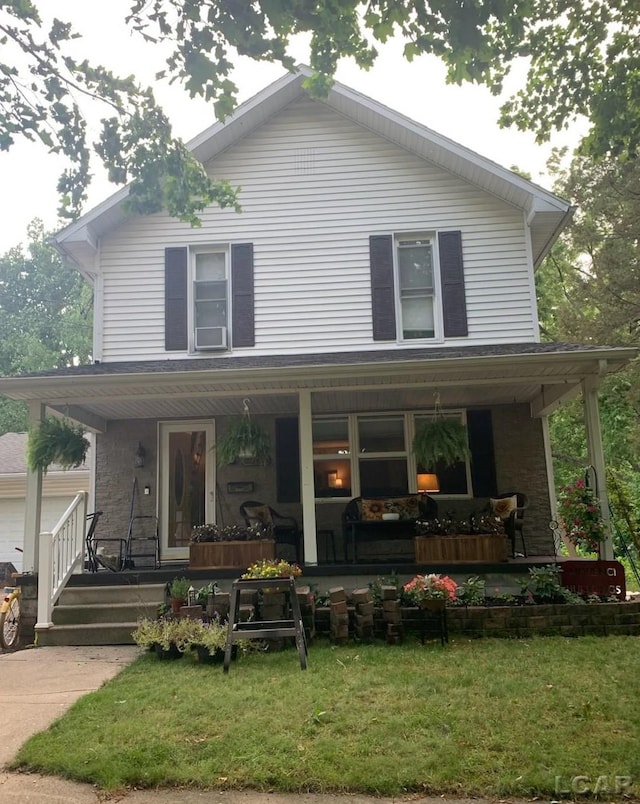 rear view of property featuring a lawn and a porch