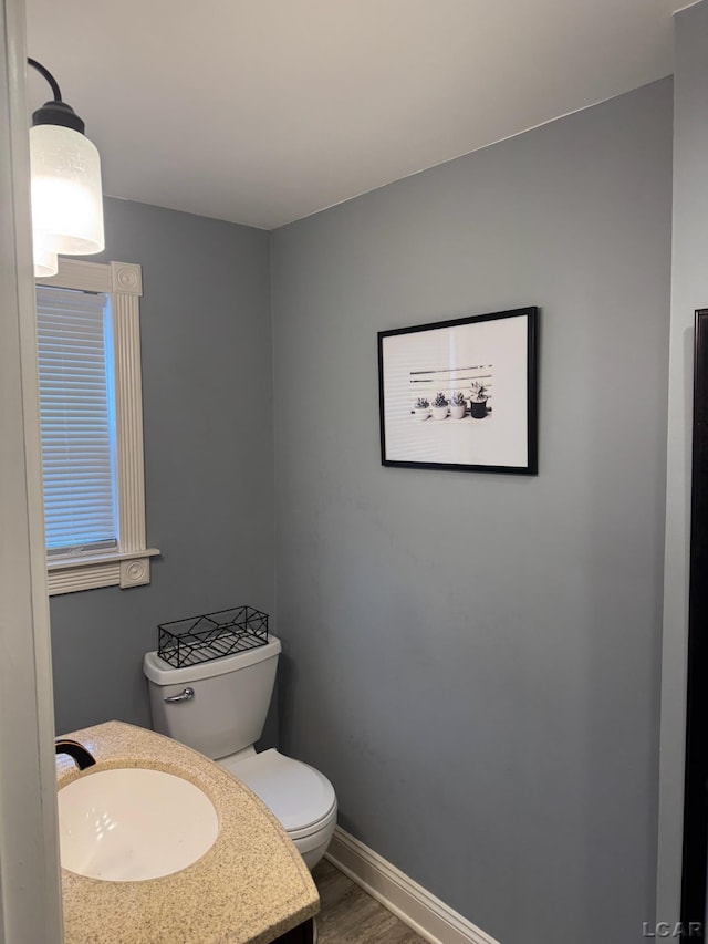 bathroom featuring hardwood / wood-style flooring, toilet, and sink