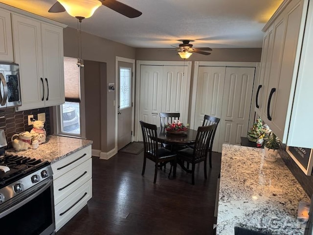 kitchen with backsplash, white cabinetry, dark wood-type flooring, and appliances with stainless steel finishes