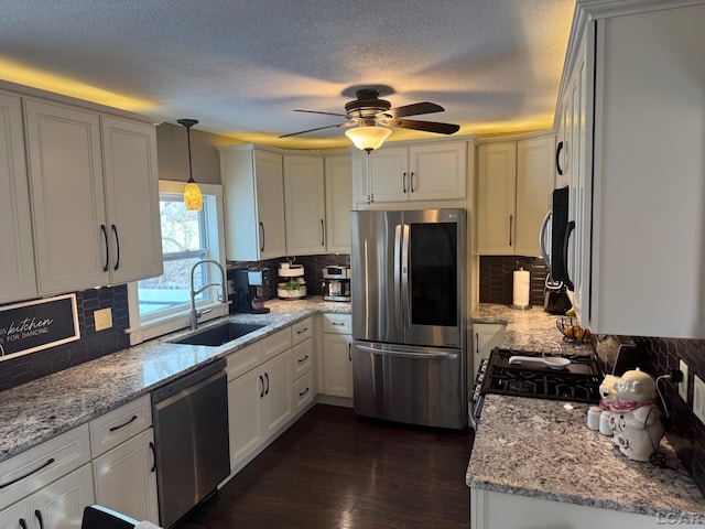 kitchen with decorative backsplash, stainless steel appliances, dark wood-type flooring, sink, and hanging light fixtures