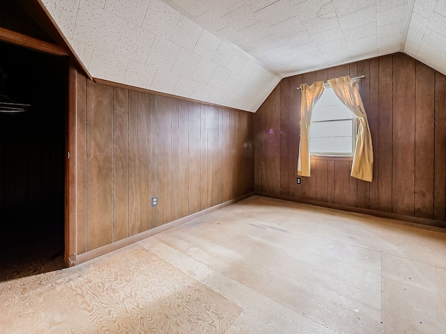 bonus room featuring wooden walls and vaulted ceiling