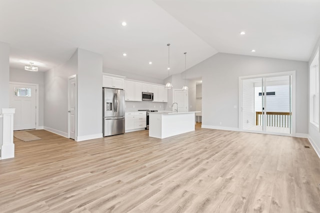 kitchen with white cabinetry, decorative light fixtures, light hardwood / wood-style flooring, an island with sink, and stainless steel appliances