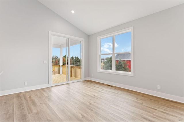 unfurnished room featuring lofted ceiling and light wood-type flooring