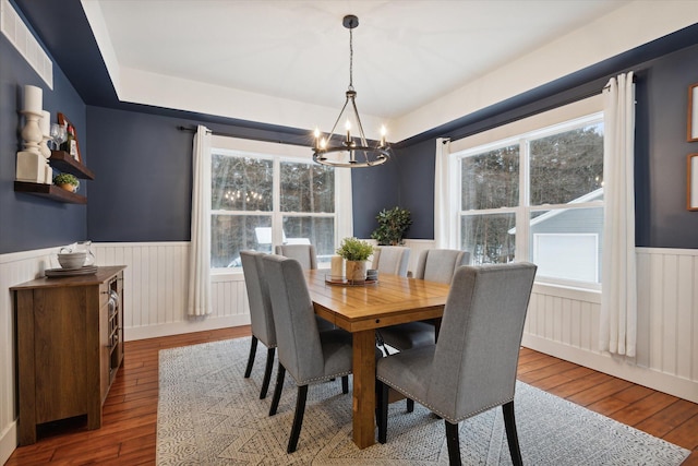 dining room with hardwood / wood-style floors and a notable chandelier