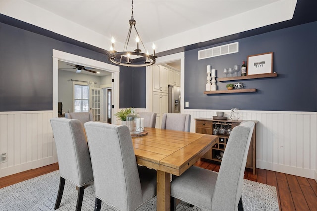 dining area with light hardwood / wood-style flooring and ceiling fan with notable chandelier