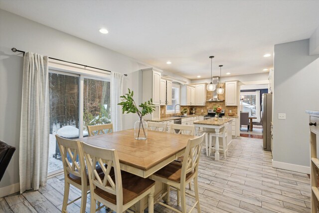 dining space featuring sink and light wood-type flooring