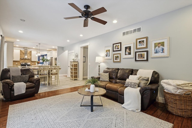 living room with light hardwood / wood-style flooring and ceiling fan