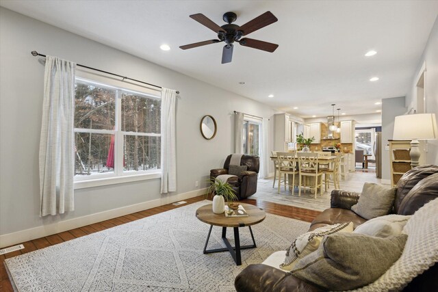 living room featuring light wood-type flooring and ceiling fan