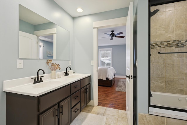 bathroom with hardwood / wood-style floors, vanity, tiled shower / bath combo, and ceiling fan