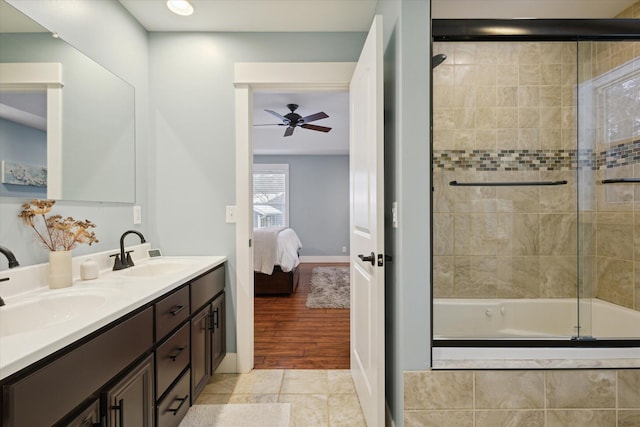 bathroom with ceiling fan, wood-type flooring, bath / shower combo with glass door, and vanity