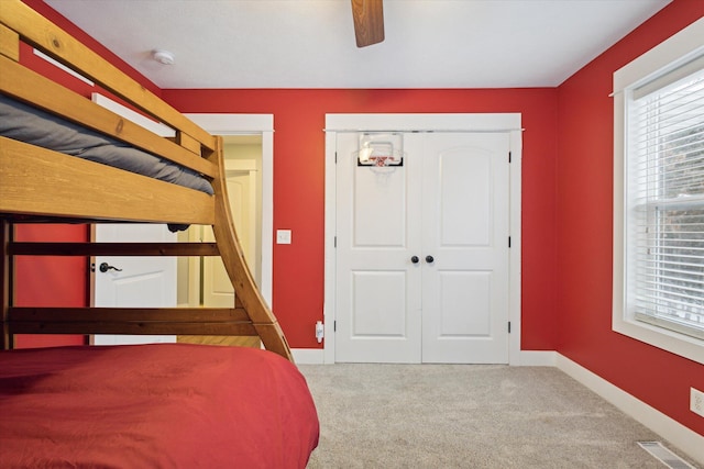 unfurnished bedroom featuring carpet, ceiling fan, and a closet