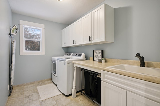 washroom with cabinets, separate washer and dryer, and sink