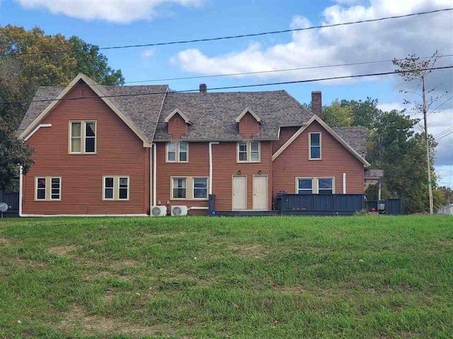 rear view of property featuring a lawn