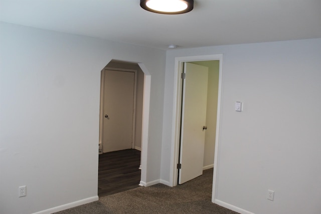 spare room featuring dark colored carpet