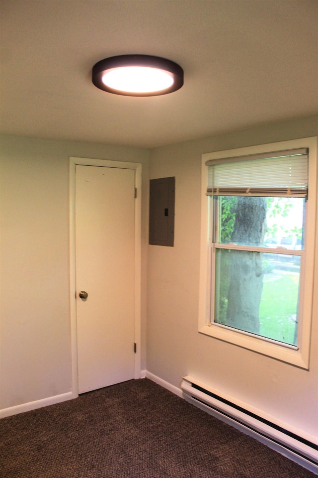 carpeted spare room featuring electric panel and baseboard heating