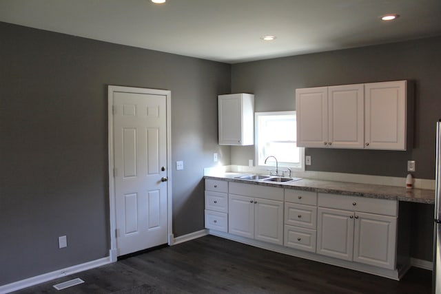 kitchen featuring dark hardwood / wood-style floors, white cabinetry, and sink