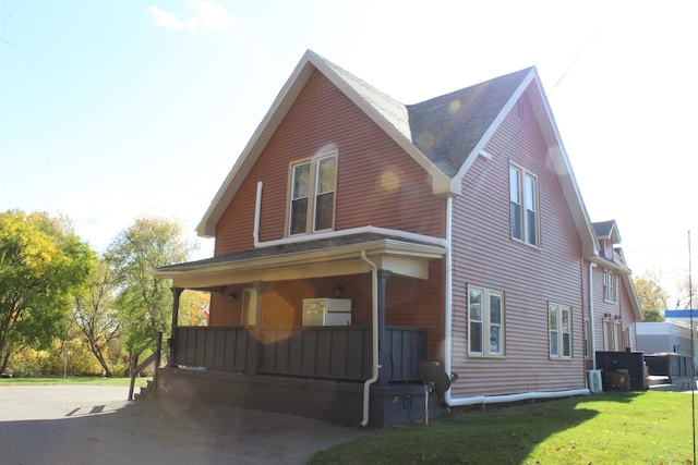 view of front of house featuring a porch, central AC, and a front lawn