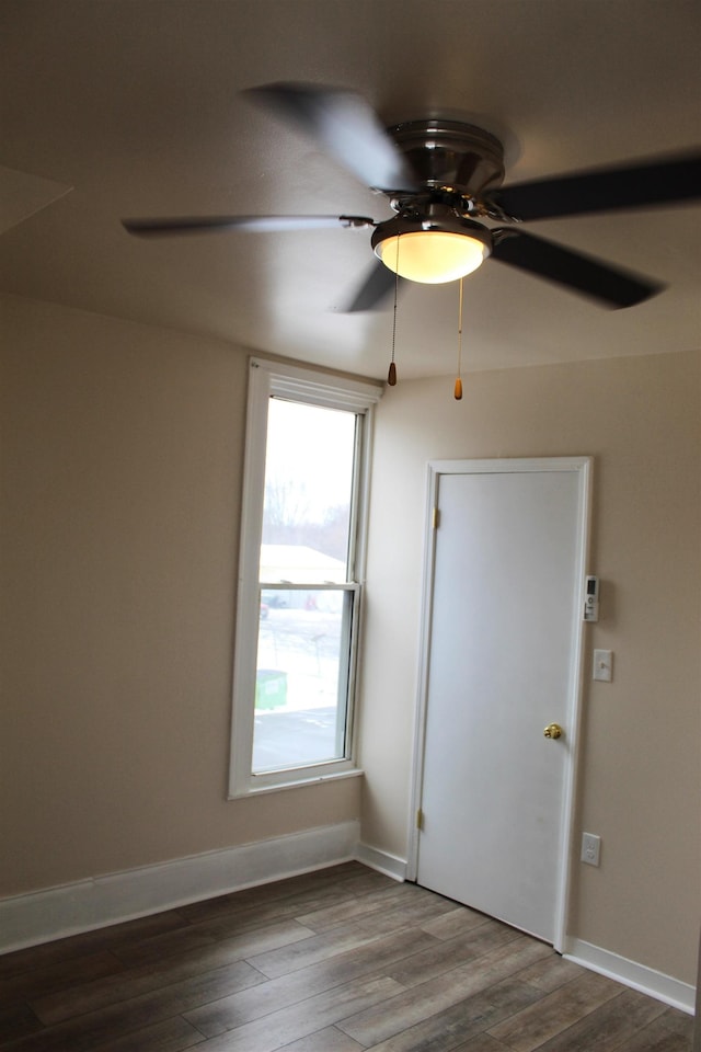 unfurnished room with ceiling fan and dark wood-type flooring