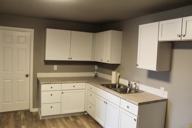 kitchen featuring white cabinets, sink, and dark wood-type flooring