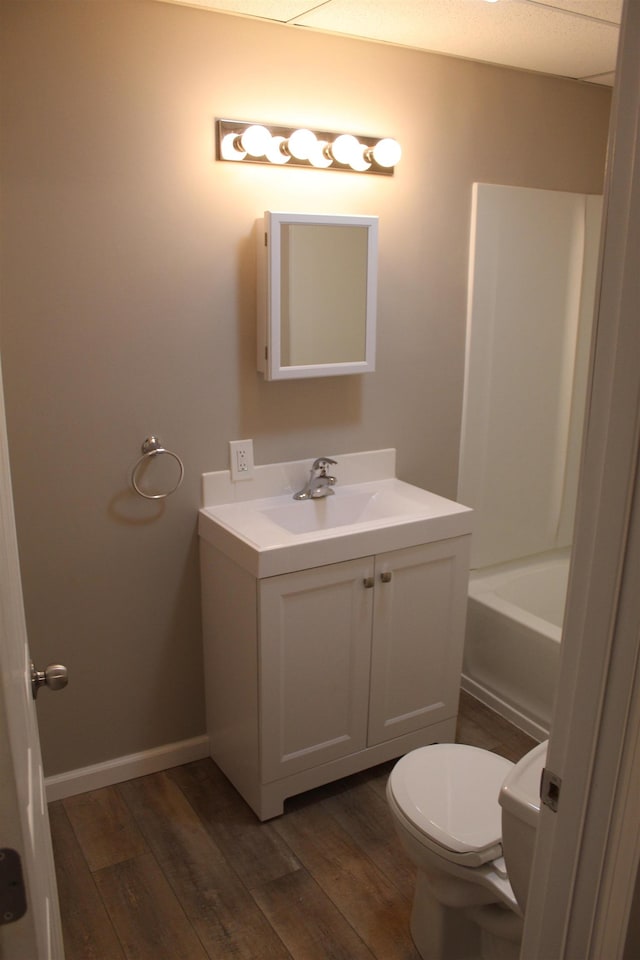 bathroom with a bathtub, toilet, vanity, and hardwood / wood-style flooring