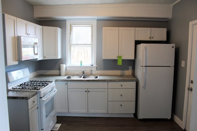 kitchen featuring a textured ceiling, white appliances, dark wood-type flooring, sink, and white cabinets