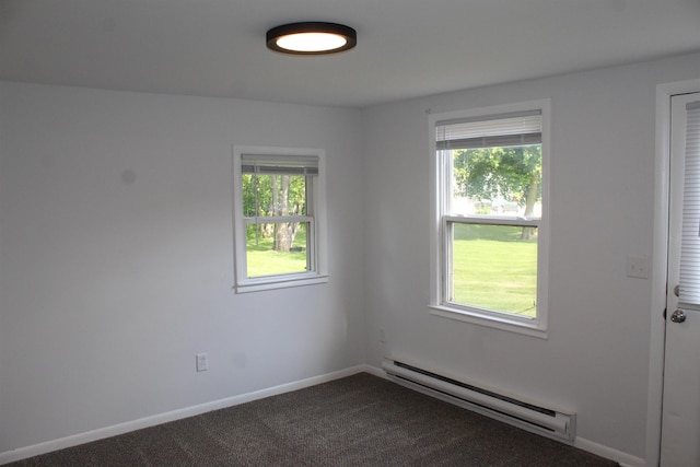 carpeted empty room with a healthy amount of sunlight and a baseboard heating unit