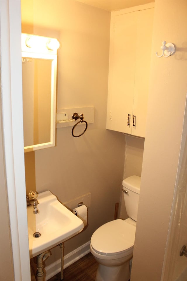 bathroom with hardwood / wood-style floors, toilet, and sink