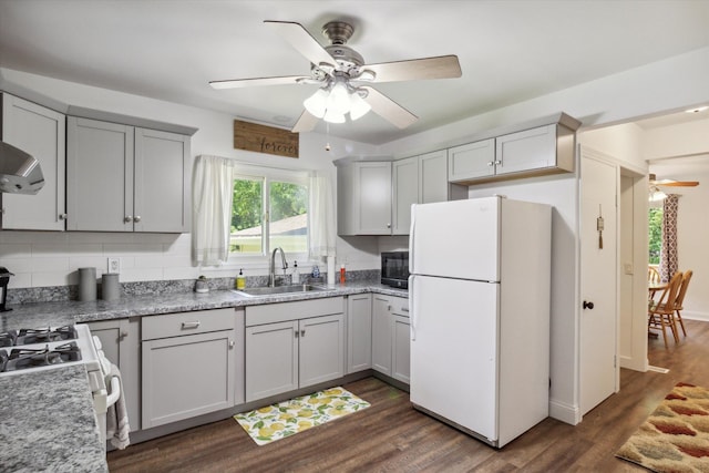 kitchen with ceiling fan, sink, dark hardwood / wood-style flooring, backsplash, and white appliances