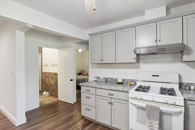 kitchen with gas range gas stove, light stone countertops, tasteful backsplash, dark hardwood / wood-style flooring, and gray cabinets